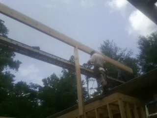 Carpenter setting a ridge beam over a new addition frame — Ice Dam Removal by Roofing Brothers in Wood River Junction