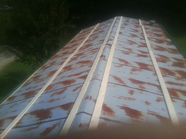 Rusted metal roof panels with new wood purlins before replacement — Storm Damage Roof Repair in Wood River Junction by Roofing Brothers