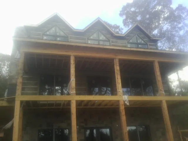 Dormers and porch framing on a large log home under construction — Roof Coating work by our crew in Wood River Junction