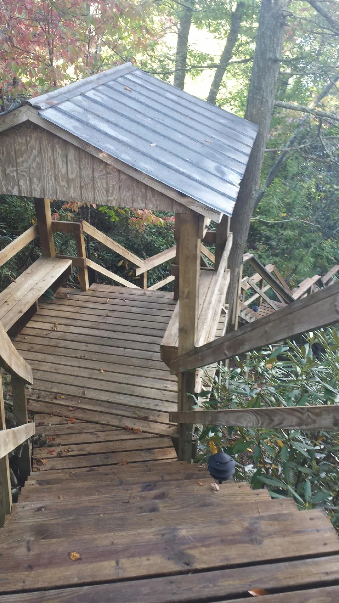 Metal roofed shelter over wooden steps on a wooded walkway — Skylight Repair & Installation work by our crew in Wood River Junction