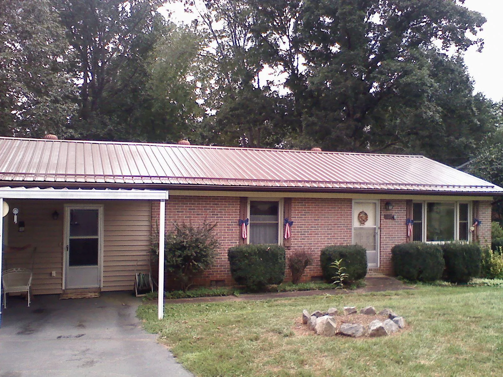 Bronze metal roof and carport on a brick ranch home — Roof Repair work by our crew in Wood River Junction